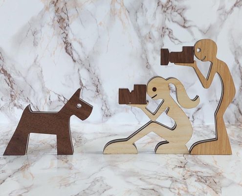 Layered wooden sculpture of young photographers with walnut cameras - plywood and clear acrylic Kerry-inspired freestanding decor