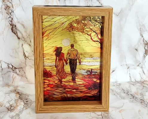 Romantic couple walking on sunset beach sublimated on clear acrylic creating stained glass window effect in wooden frame