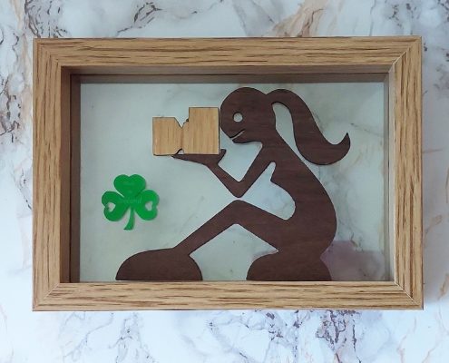 Framed wooden art featuring woman photographer with plywood camera and green acrylic shamrock - walnut and acrylic Irish-themed decor02